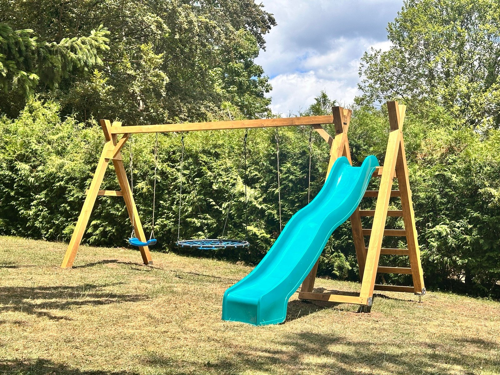 Nestschaukel und Rutsche im Garten der Pension